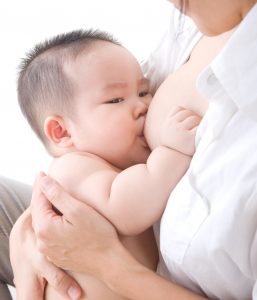 a baby breastfeeding/chestfeeding