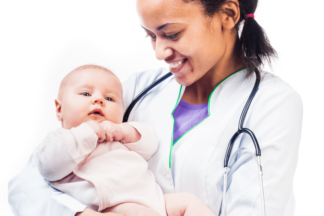 A healthcare professional in a white coat with green trim, wearing a stethoscope, holding an infant.