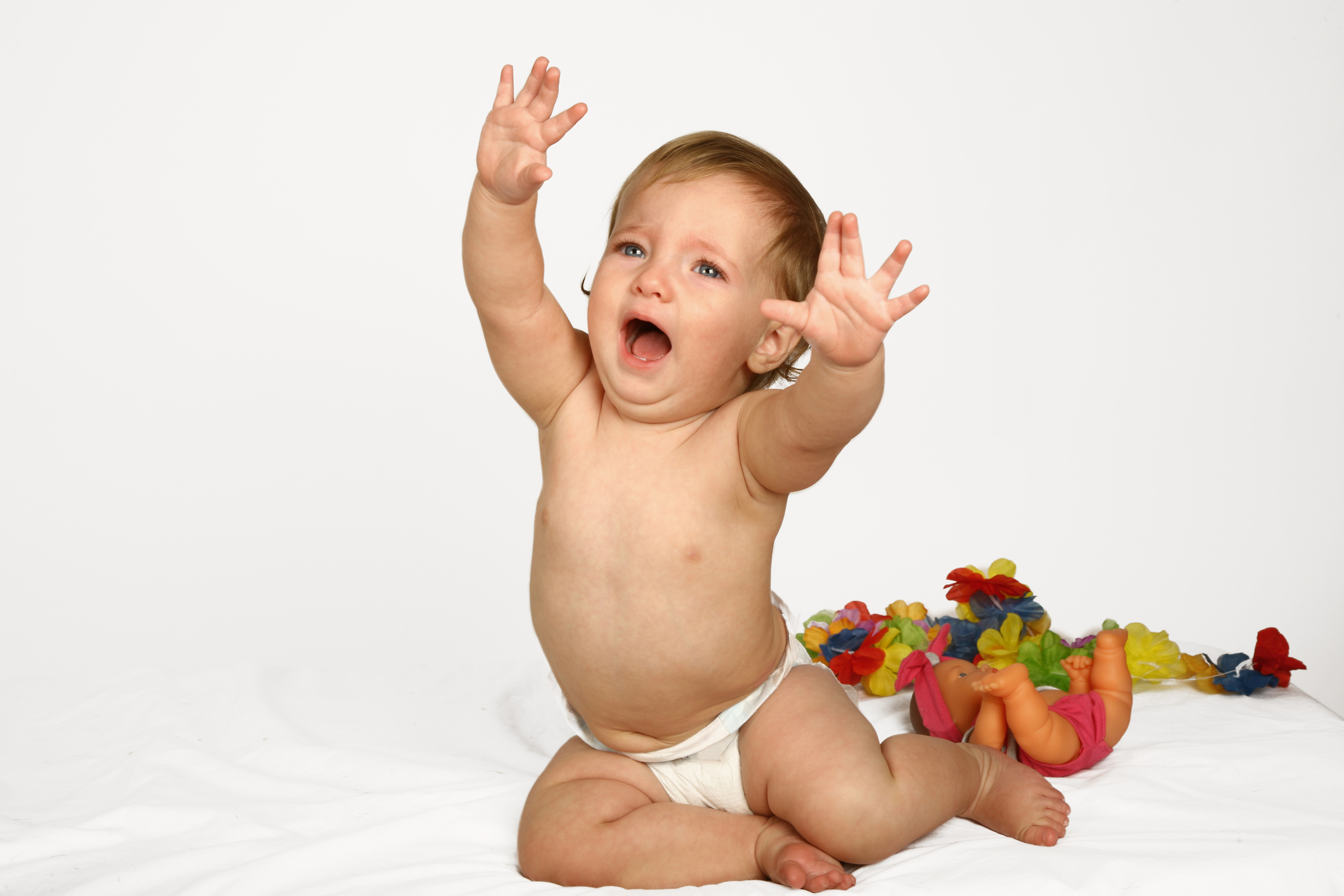 A baby crying and reaching their arms up.