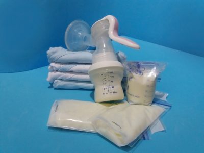 A manual breast pump and bags of breast/chest milk.