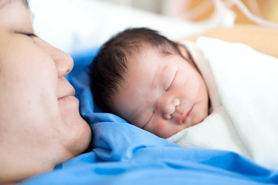 Parent holding a newborn in the hospital