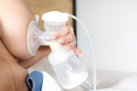  A single electric breast pump latched onto a breast.